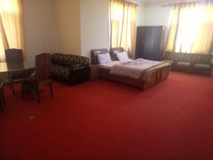 a bedroom with a bed and a chair and a desk at Bhaderwah Valley Resort in Bhadarwāh