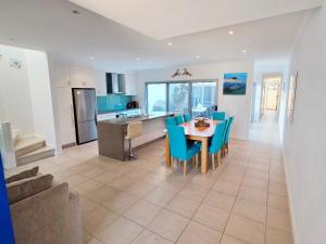 a kitchen and dining room with a table and chairs at Waves at Jurien, Villa 9-23 Dalton Street in Jurien Bay +4 photos