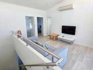 a living room with a couch and a tv at Waves at Jurien, Villa 9-23 Dalton Street in Jurien Bay