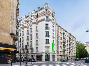 a white building with a green sign on it at ibis Styles Paris 15 Lecourbe in Paris