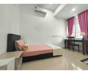 a bedroom with a bed and a desk in a room at 61 StayAtHome in Nibung Tebal