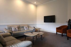 a living room with a couch and a flat screen tv at Q Station in Sydney