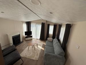 a living room with a couch and a tv at Chalet Vida in Petten