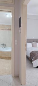 a bedroom with a tub and a bed and a television at "Alsos View" in Agrinio +4 photos