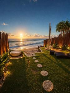 a garden with a view of the ocean at sunset at Bubble 4 - Romantic With Bath Uluwatu in Uluwatu