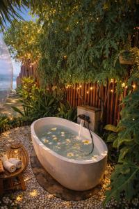 a bath tub with a fountain in a garden at Bubble 4 - Romantic With Bath Uluwatu in Uluwatu