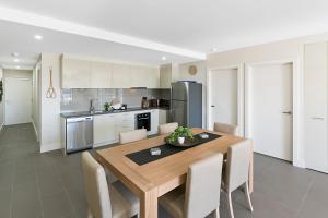 een keuken met een houten eettafel en stoelen bij Salt 15 Luxury Apartment in Sorrento