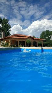 una piscina de agua azul frente a una casa en Casona Aventurados en Luján de Cuyo