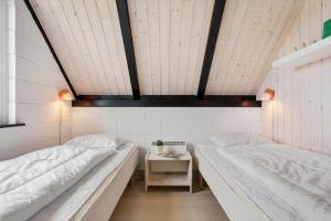 a room with two beds and a table at 274-Ringkobing-Nordso-Ferievej-86 in Nørre Lyngvig