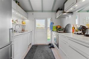 a kitchen with white cabinets and a white door at FY298-Faaborg-Dybskrog-12 in Faaborg +14 photos