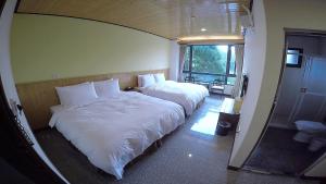 1 dormitorio con 2 camas y ventana grande en Nantou Sunmoon Lake Walami Homestay B&B, en Yuchi