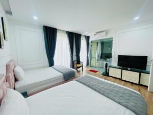 a hotel room with two beds and a flat screen tv at Villa 184 HABOBAY in Ha Long +35 photos