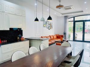 a kitchen and living room with a wooden table at Villa 184 HABOBAY in Ha Long