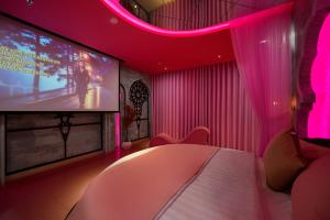 a room with a bed and a tv and pink lighting at Chiic House Hải Phòng in Lực Hánh