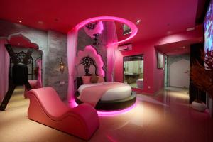 a pink bedroom with a bed and a chair at Chiic House Hải Phòng in Lực Hánh