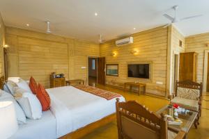 a bedroom with a large bed and a television at Hotel Golden Haveli in Jaisalmer