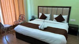 a bedroom with a large bed with a white animal on it at Hotel Grand Shiva in Gupta Kāshi +2 photos