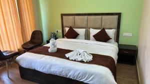 a bedroom with a large bed with two towels on it at Hotel Grand Shiva in Gupta Kāshi
