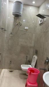a bathroom with a toilet and a sink and a bucket at Hotel Grand Shiva in Gupta Kāshi