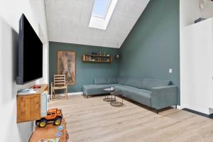a living room with a couch and a tv at 1616-Frederiksvaerk-Skovbrynet-7 in Frederiksværk
