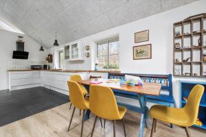 a kitchen with a wooden table and yellow chairs at 1616-Frederiksvaerk-Skovbrynet-7 in Frederiksværk