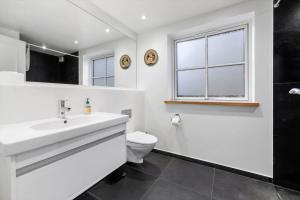 a white bathroom with a sink and a toilet at 1616-Frederiksvaerk-Skovbrynet-7 in Frederiksværk +20 photos