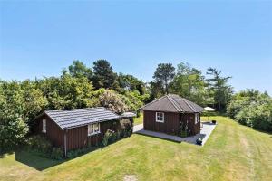 two small cottages on a grass field with trees at SL078-Slagelse-Dybkaervej-36 in Slagelse