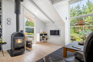 a living room with a fireplace and a tv at 30305-Ulfborg-Bellisvej-504 in Ulfborg