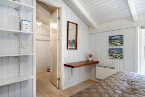 a bedroom with a bed and a mirror at 30305-Ulfborg-Bellisvej-504 in Ulfborg