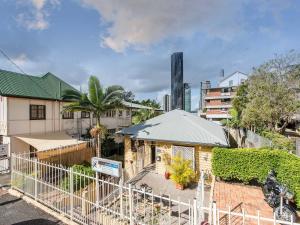 a house with a fence in front of a city at Kookaburra Inn in Brisbane