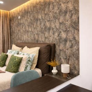 a bedroom with a couch and a wall with a wallpaper at Moonlit Terrace Escape in St. Paul's Bay