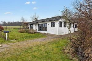 a small white house in a grassy field at SB122-Augustenborg-Gronvej-3 in Asserballeskov