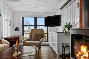 a living room with a fireplace and a tv at SB122-Augustenborg-Gronvej-3 in Asserballeskov