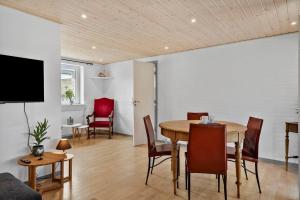 a dining room with a table and chairs at LF10243-Thyholm-Krumborgvej-3 in Hvidbjerg +10 photos