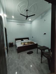 a bedroom with a bed and a ceiling fan at Prem Saroj homestay in Ayodhya +9 photos