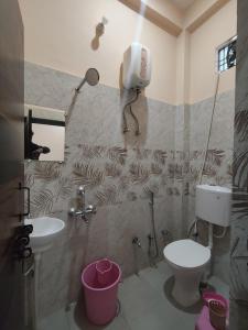 a bathroom with a toilet and a sink at Prem Saroj homestay in Ayodhya