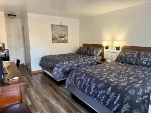 a hotel room with two beds and a desk at John Day Motel in John Day