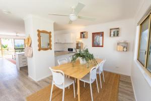 a kitchen and dining room with a wooden table and chairs at Jara - U19 Pandanus Palms Resort in Point Lookout