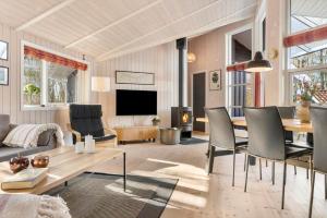 a living room with a table and chairs and a television at LF12022-Spottrup-Skovmarken-2 in Vadum