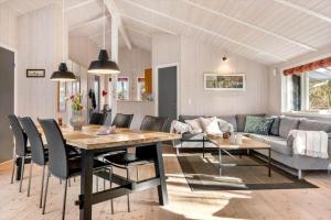 a dining room and living room with a table and chairs at LF12022-Spottrup-Skovmarken-2 in Vadum