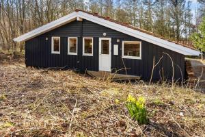 a black shed with a white door on a field at LF12022-Spottrup-Skovmarken-2 in Vadum