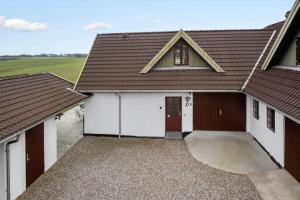 a building with two garage doors and a brown roof at FY410-Faaborg-Mosetoften-10-B in Diernæs