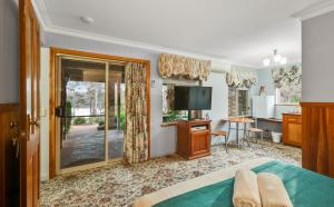 a bedroom with a bed and a flat screen tv at Robyn's Nest Lakeside Resort in Merimbula