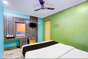 a bedroom with a bed and a green wall at KVS Residency in Tiruvallam