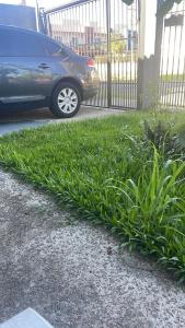 a patch of green grass next to a car at CampAmbrosi in Sapiranga