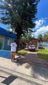 a person standing next to a red fence at CampAmbrosi in Sapiranga
