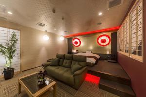 a bedroom with a bed and a couch at ホテル彩柏市若柴店 in Kashiwa