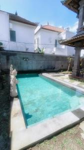 a swimming pool in front of a house at Uma Kutuh Bungalow in Ubud