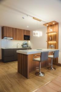 a kitchen with a counter and two bar stools at Saya Hotel & Suites in Cuenca