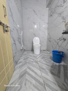 a bathroom with a toilet and a sink and marble walls at Sree Guru Sannidhi in Jāmb